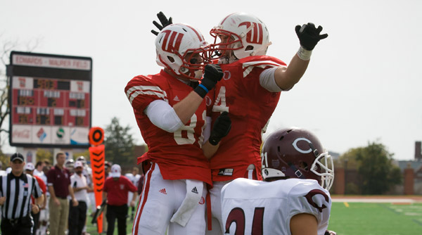 Jonathan Stoner (81) and Stephen Zumdick (84) celebrate a second-quarter touchdown for the Tigers as they romped past Chicago, 41-17. Photo by Erin Pence