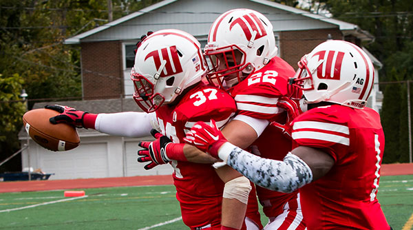 Nick Gibson (37) celebrates one of Wittenberg's seven turnovers with teammates Gabe Cunningham (22) and Victor Banjo (1). Photo by Erin Pence